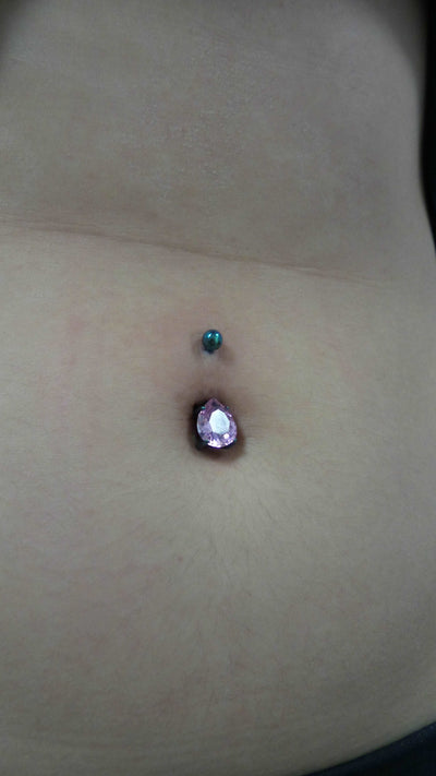 Purple gemstone jewelry worn in a navel piercing