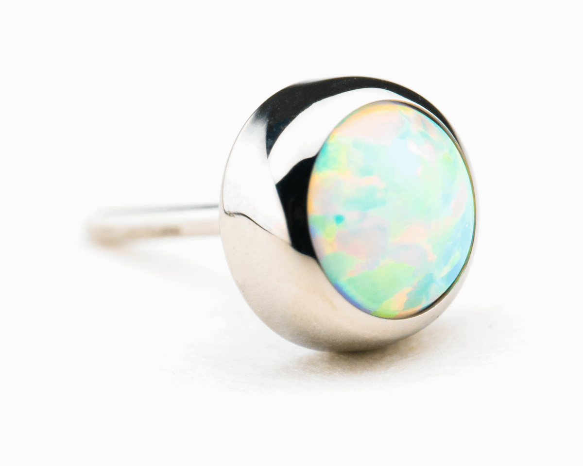 Pale blue-white synthetic opal in a polished titanium threadless setting