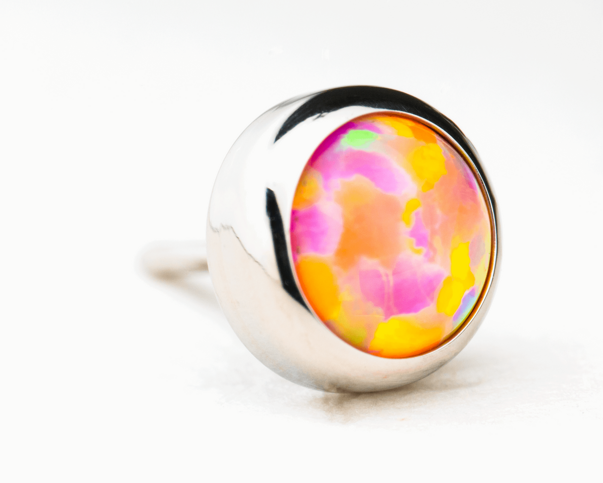 Pink and orange synthetic opal in a polished titanium threadless setting