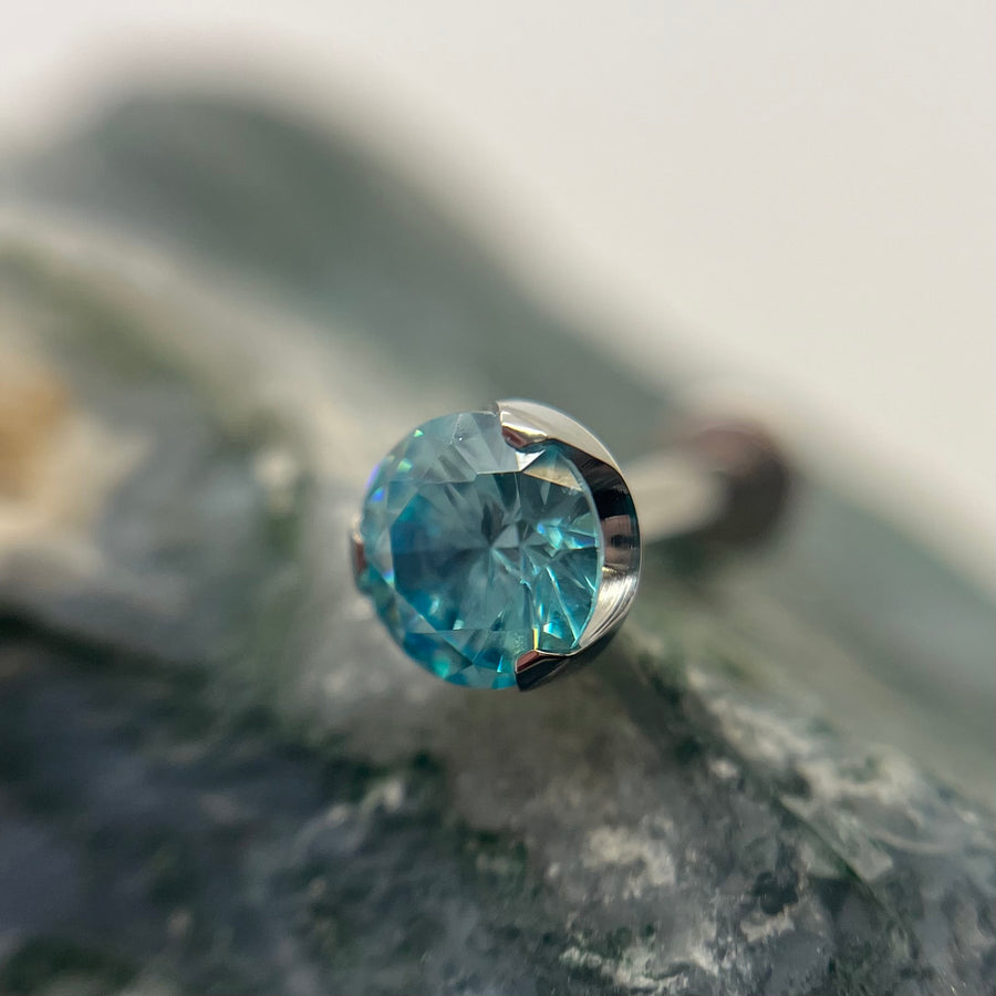 Aqua-coloured 3 mm prong-set titanium bead with backing, made in Calgary by Tribal Expression